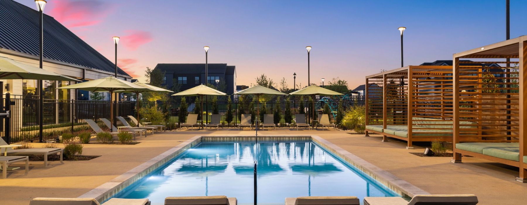 a large community swimming pool with cabanas at a BTT community
